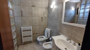 Un baño con lavabo, inodoro y espejo. en Apart Centro Paraná Apartamento entero 90m2, cochera privada para auto, excelente ubicación, a mts del Shopping Paso del Paraná, zona Parque y Peatonal, en Paraná