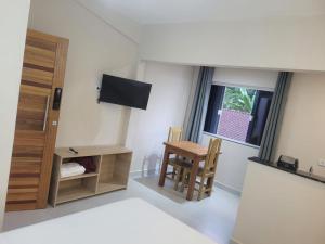 a room with a bed and a table and a tv at Condomínio Pickler in Juquei