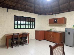 a kitchen with a wooden table and a refrigerator at Cabañas y hospedaje Sol y Luna Motul in Motul de Felipe Carrillo Puerto