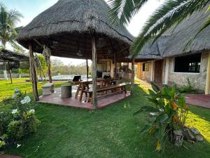 a pavilion with a picnic table and a thatch roof at Cabañas y hospedaje Sol y Luna Motul in Motul de Felipe Carrillo Puerto