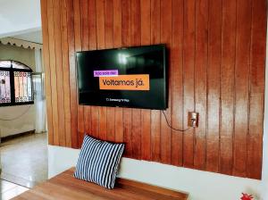 una televisione su una parete di legno con un cuscino di Mi Casa Rio Garagem Wi-Fi Grátis Próximo Praia Barra a Rio de Janeiro
