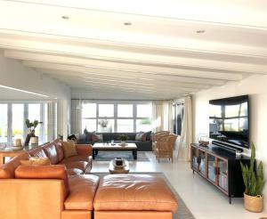 a living room with a couch and a tv at The Cape Cottage in Yzerfontein