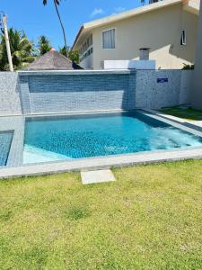 una piscina davanti a una casa di Apartamento de luxo à beira-mar a Tamandaré