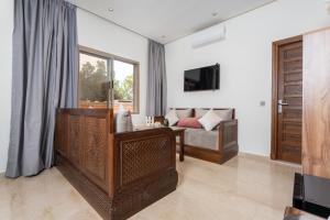 Una sala de estar con un sofá y un televisor. en Dar Nourdha, en Marrakech
