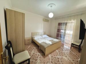 a bedroom with a bed and a chair and a window at House Hasa in Krujë