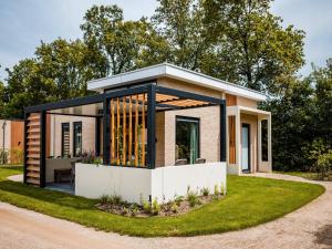 una casa pequeña con muchas ventanas en Holiday Home in Veluwe near Nature Trails, en Voorthuizen