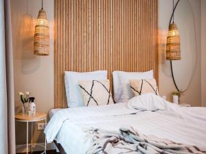 Un dormitorio con una cama con sábanas y almohadas blancas. en Holiday Home in Veluwe near Nature Trails, en Voorthuizen