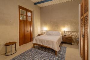 a bedroom with a bed and a wooden door at Casa Tunkul in Mérida +38 photos