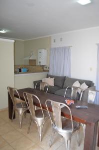 a dining room table with chairs and a couch at Complejo Fatima in Villa Dolores