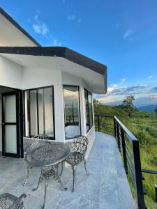 een terras met een tafel en stoelen op een balkon bij Esmeralda PLUS in San Gil