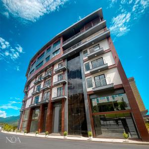 a tall building with a blue sky in the background at Nöa Hotel in Piñas