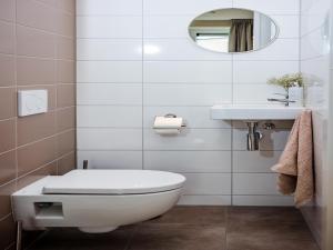 a white bathroom with a toilet and a sink at Holiday Home in Voorthuizen near Veluwe in Voorthuizen +32 photos