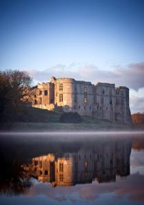 a castle with its reflection in the water at Sleeps 7 in Pembrokeshire