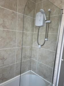 a shower with a shower head in a bathroom at Sleeps 7 in Pembrokeshire +19 photos