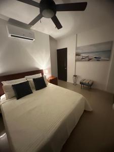 a bedroom with a white bed with a ceiling fan at Villa Verde 2 Casa 14 in Tamarindo +47 photos