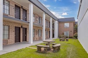 a courtyard with two picnic tables and buildings at Best Western of Alexandria Inn & Suites & Conference Center in Alexandria