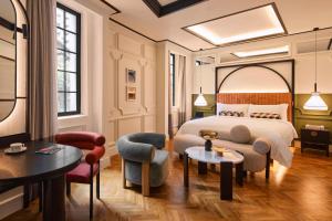 a hotel room with a bed and two chairs at QT Singapore in Singapore