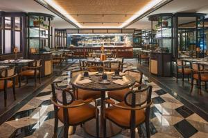 a restaurant with tables and chairs and a bar at QT Singapore in Singapore