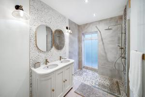 a bathroom with a sink and a shower with mirrors at Portsalon Cottage in Portsalon +22 photos