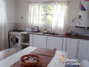 a kitchen with a bowl of eggs on a table at Postal del Golfo in Las Grutas +14 photos