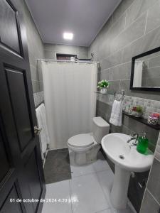 a bathroom with a white toilet and a sink at DEPARTAMENTOs HABY 1 in Paquera +14 photos
