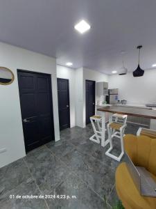 a kitchen with a counter and chairs in a room at DEPARTAMENTOs HABY 1 in Paquera