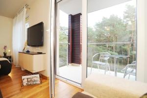 a living room with a sliding glass door leading to a balcony at Apartament Jurata in Jurata