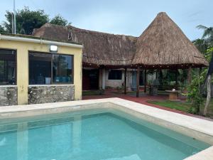 a resort with a swimming pool in front of a building at Cabañas y hospedaje Sol y Luna Motul in Motul de Felipe Carrillo Puerto