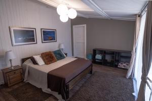 a bedroom with a bed and a table and a window at Riveras Rentals Bosque , cabañas & cabinas in Algarrobo
