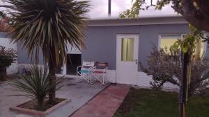 a house with a table and chairs in front of it at Apart San Benito in Trelew