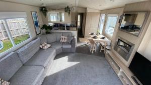 a living room with a couch and a table at Cosy Holiday Home at Seton Sands near Edinburgh and North Berwick in Port Seton