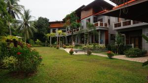 a courtyard of a building with a grass yard at Lanta Intanin Resort - SHA Extra Plus in Ko Lanta