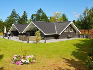 una casa grande con un patio con flores en Bright Cottage with Hot Tub - By Traum Ferienwohnungen, en Bøtø By