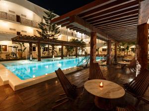 a swimming pool with chairs and a table and a swimming pool at HM Playa del Carmen in Playa del Carmen