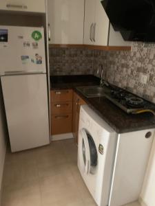 a kitchen with a white refrigerator and a washing machine at Nativo Otel in Antalya +10 photos