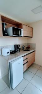 una cucina con forno a microonde e frigorifero di Flat Aldeia das Águas a Volta Redonda Altre 15 foto