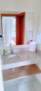 un bagno con lavandino e specchio di Flat Aldeia das Águas a Volta Redonda