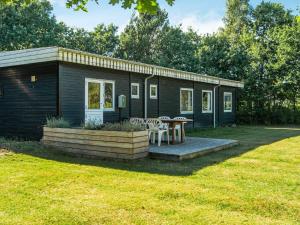 a small cabin with a table and chairs in a yard at 6 person holiday home in Ørsted-By Traum in Ørsted