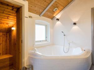 a large white tub in a bathroom with a window at 5 person holiday home in Henne in Henne Strand +40 photos