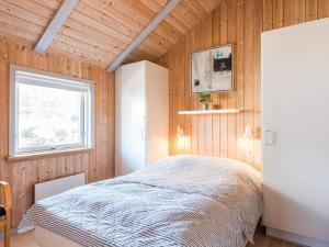 a bedroom with a bed in a wooden wall at 5 person holiday home in Henne in Henne Strand