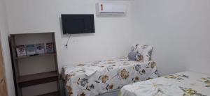 a bedroom with a bed and a tv on the wall at Suite da Barra in Barra Grande