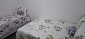 a bedroom with a bed with a floral bedspread at Suite da Barra in Barra Grande