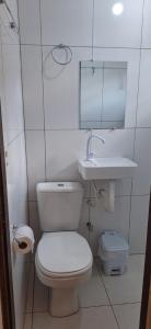 a white bathroom with a toilet and a sink at Suite da Barra in Barra Grande