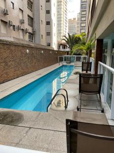a swimming pool on the side of a building at Flat Alto Padrão Quadra da Praia in Santos