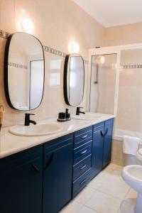 a bathroom with two sinks and two mirrors at Funchal Sunset Apartment in Funchal
