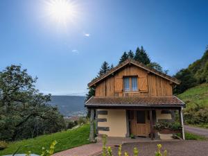 a small house on a hill with the sun behind it at Maison montagnarde rénovée avec cheminée et randonnées - FR-1-589-281 in Saulxures-sur-Moselotte