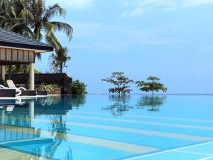 a swimming pool with a view of the ocean at Blue Joys MSR in Siquijor