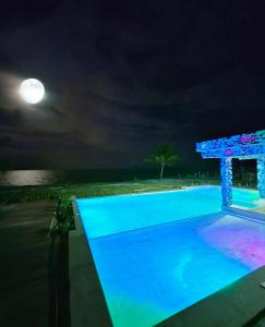 a swimming pool at night with the moon in the sky at Estância Pedacinho do Céu Prado Bahia in Prado