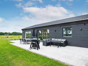 Ansagerにある10 person holiday home in Ansagerのテーブルと椅子のあるパティオと建物