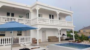 una casa bianca con piscina e ombrellone di New condo with sea view 3 a Wheeland Settlement